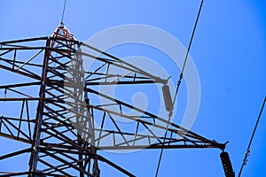 A power line tower with a blue sky in the background
