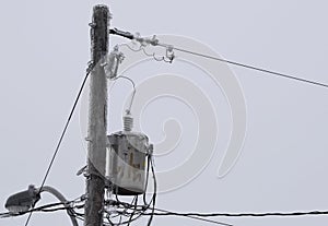 Power line transformer covered in ice, closeup