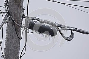 Power line transformer covered in ice, closeup