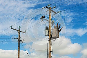 Power line with wooden poles on a green field