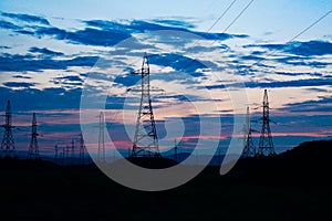 Power lines against dark sunset sky