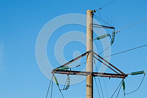 Power lines on the background of the blue sky close-up. Electric hub on a pole. High voltage wires