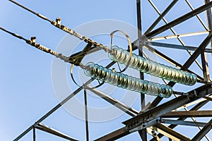 Power lines on background of blue sky close-up. Electricity equipment with copy space. Wires of high voltage in sky.