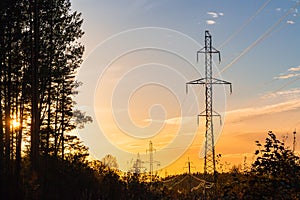 Power lines on the background of forest and sky at sunset