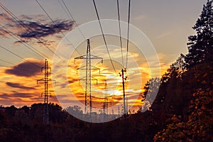 Power lines on the background of forest and sky at sunset