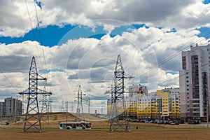 Power lines in the city near residential buildings against a blue sky