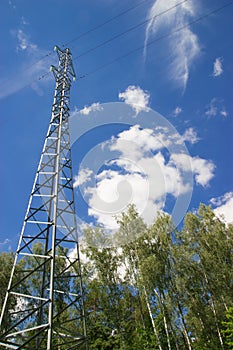 Power lines in the forest, clouds and blue sky, high voltage wires