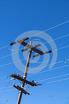 Power lines and insulators against a clear blue sky