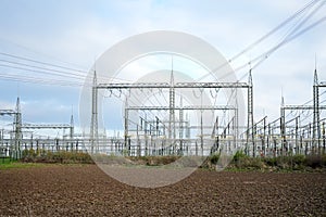 Power lines and substation, high voltage lines behind, electrical grid. High-voltage power line, transmission tower overhead line