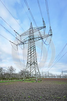 Power lines and substation, high voltage lines behind, electrical grid. High-voltage power line, transmission tower overhead line