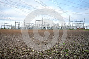 Power lines and substation, high voltage lines behind, electrical grid. High-voltage power line, transmission tower overhead line