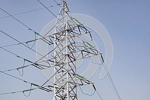 Power lines and towers - a modern high voltage power system. Against the background of the blue sky