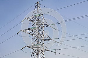 Power lines and towers - a modern high voltage power system. Against the background of the blue sky