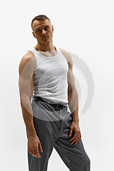 Sexy portrait of attractive muscular handsome male model posing at camera over white studio background