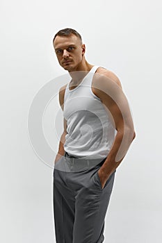 Sexy portrait of muscular handsome topless male model posing at camera over studio background