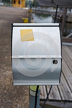 Power outlet box in the harbor with yellow empty sticker