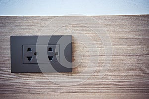 A power outlet on the wall of the house.