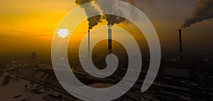 Power Plant emissions seen above the city  during sunrise. Environmental pollution. Factory pipe polluting air.Panorama sunset.