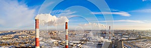 Power plant pipes on the background of the panorama of the winter city against blue sky