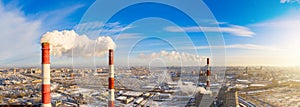 Power plant pipes on the background of the panorama of the winter city against blue sky