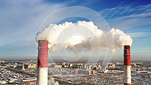 Power plant pipes on the background of the panorama of the winter city against blue sky