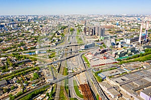 Power plant pipes and cooling towers in Moscow from above, automobile traffic and and construction of a new car overpass and