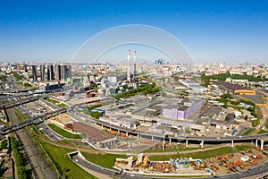 Power plant pipes and cooling towers in Moscow from above, automobile traffic and and construction of a new car overpass and