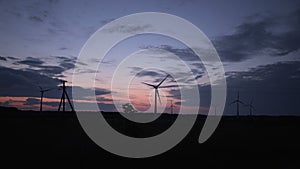 Power plant windmills spin amid beautiful sunset 4K