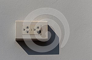 The power plug is damaged by a short circuit on a white concrete wall.
