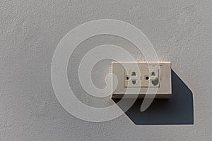 The power plug is damaged by a short circuit on a white concrete wall.