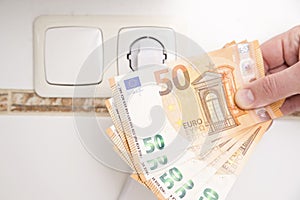 Power plug on euro banknotes. Cost of electricity and expensive energy concepts.