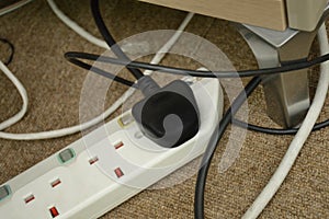 A power plugs adapter extension cord in use with black cable plug mounted