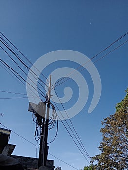 power pole with blue sky and tree photo