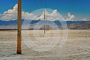 Power poles lined up down the salt flats in Utah.