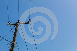 Power poles and wires against a sunny sky background