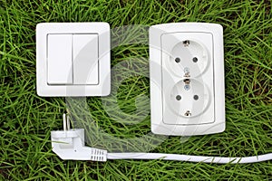 Power receptacle and light switch on a green grass