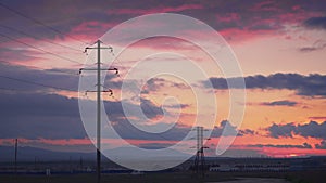 Power station with huge electric supports at sunset and a minibus with workers