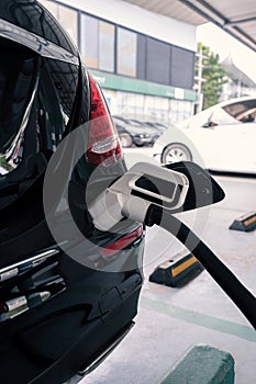 Power supply connects to plug-in electric vehicle or electric car at charging station