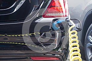 Power supply for hybrid electric car charging battery.Close up of power supply plugged into an electric car being charged