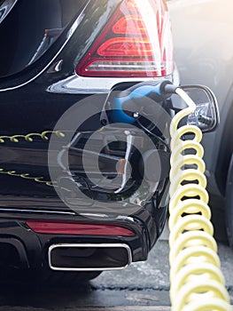 Power supply for hybrid electric car charging battery.Close up of power supply plugged into an electric car being charged