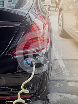 Power supply for hybrid electric car charging battery.Close up of power supply plugged into an electric car being charged