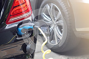 Power supply for hybrid electric car charging battery.Close up of power supply plugged into an electric car being charged