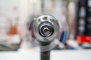 Power tool drill screw head macro close up shot in a lab isolated against bright blurry background