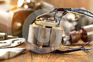 Power tool repair. Details of electrical appliance and repair tools on a wooden table in a repair shop