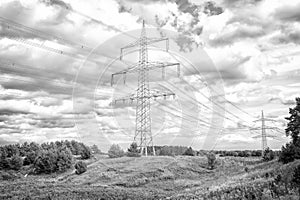 Power towers on natural landscape. Transmission towers on cloudy sky. Electricity pylon structure with power lines. High