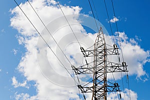 Power transmission line pole against blue cloudy sky.