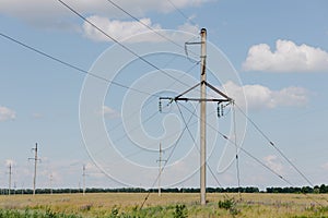 Power Transmission Towers. Air hi-voltage electric line supports at field under blue sky.