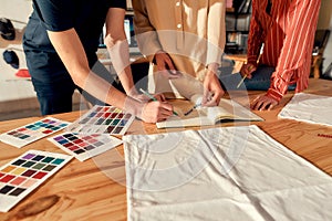 The power of us. Cropped shot of designers drawing sketches, while creating logo and design of T-shirt. Young man and