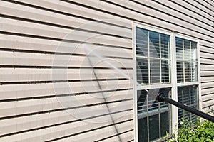 Power washing. House wall siding cleaning with high pressure water jet.