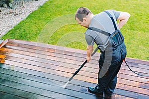 Power washing - man cleaning terrace with a power washer